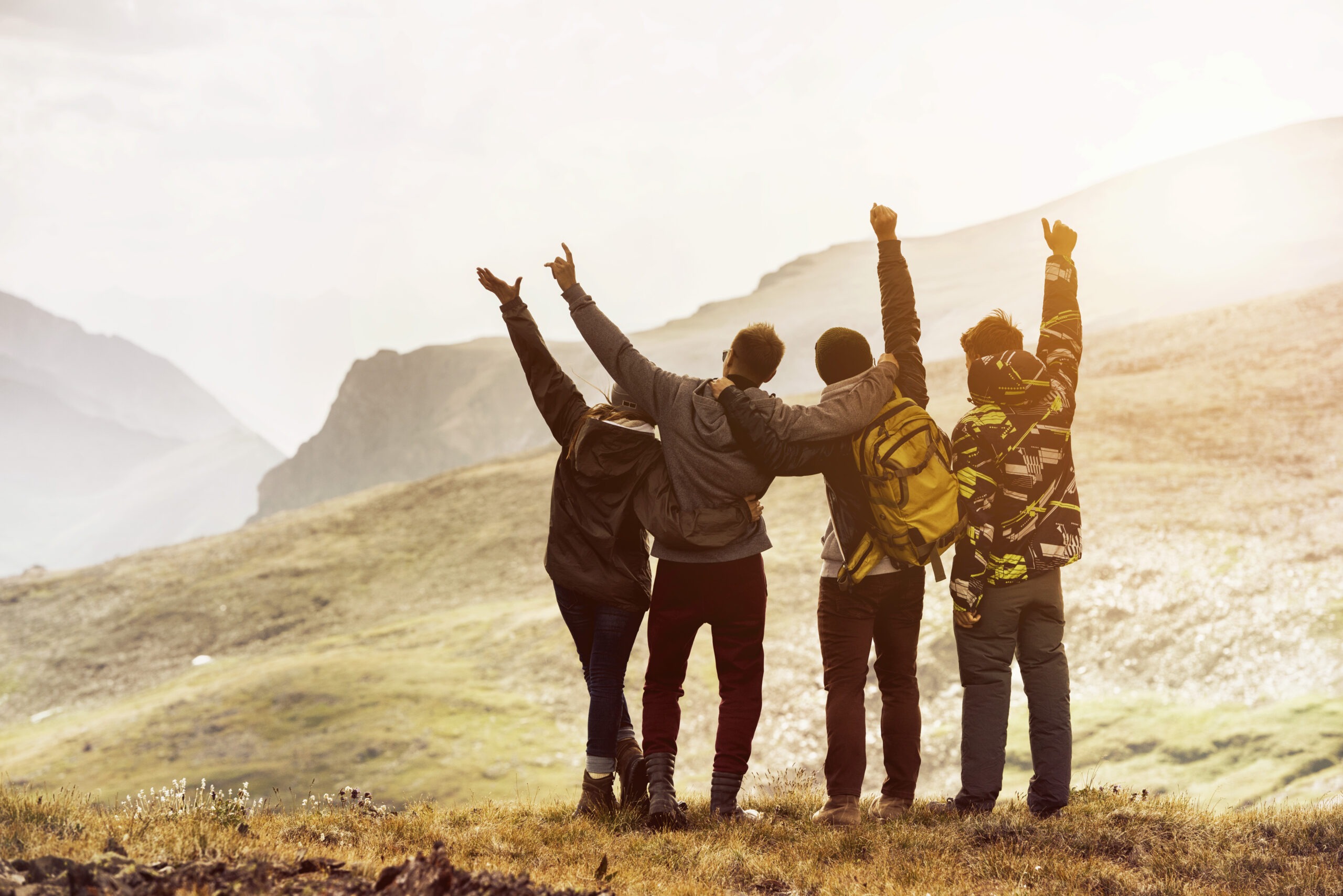 Four friends having fun mountain sunset